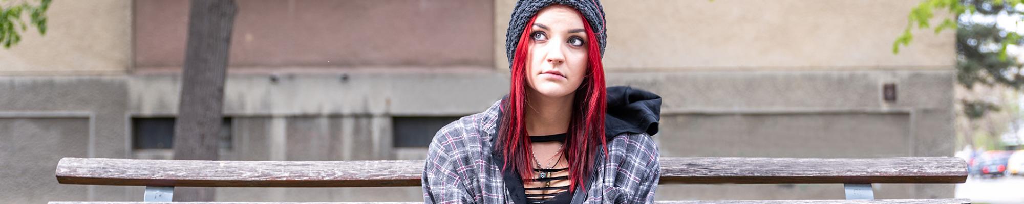 Homeless teenager sitting on bench